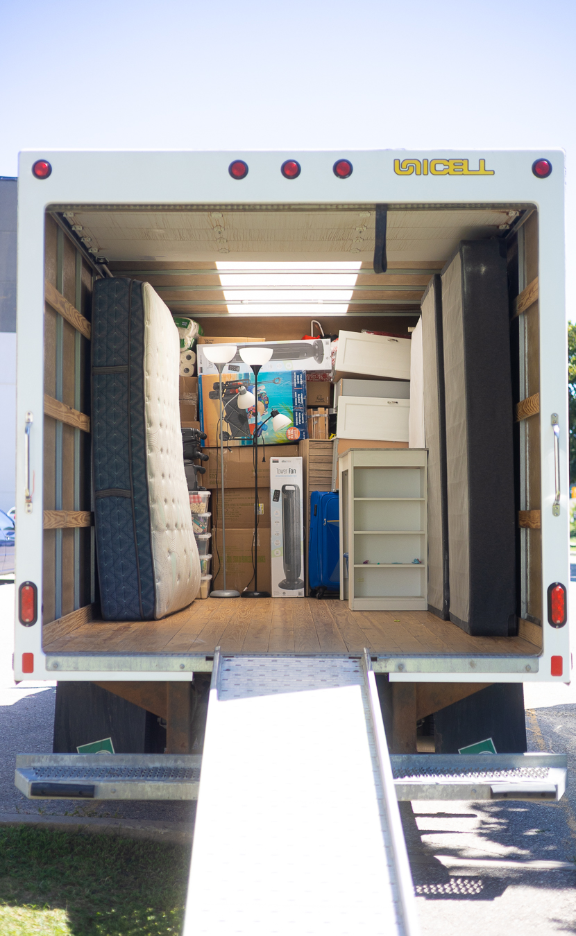 Interior of a Rooster Movingz moving truck loaded with mattresses, boxes and furniture